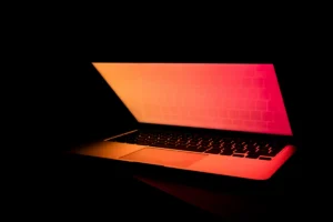A red glowing laptop in the dark